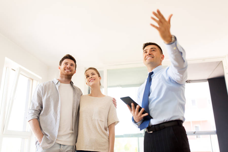 Couple with real estate agent looking at property after securing an Investment Property Loan in Perth